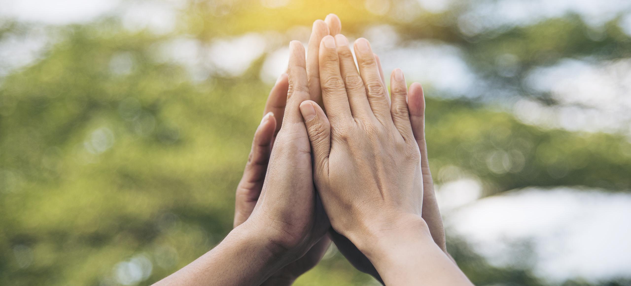 Several hands clap together 