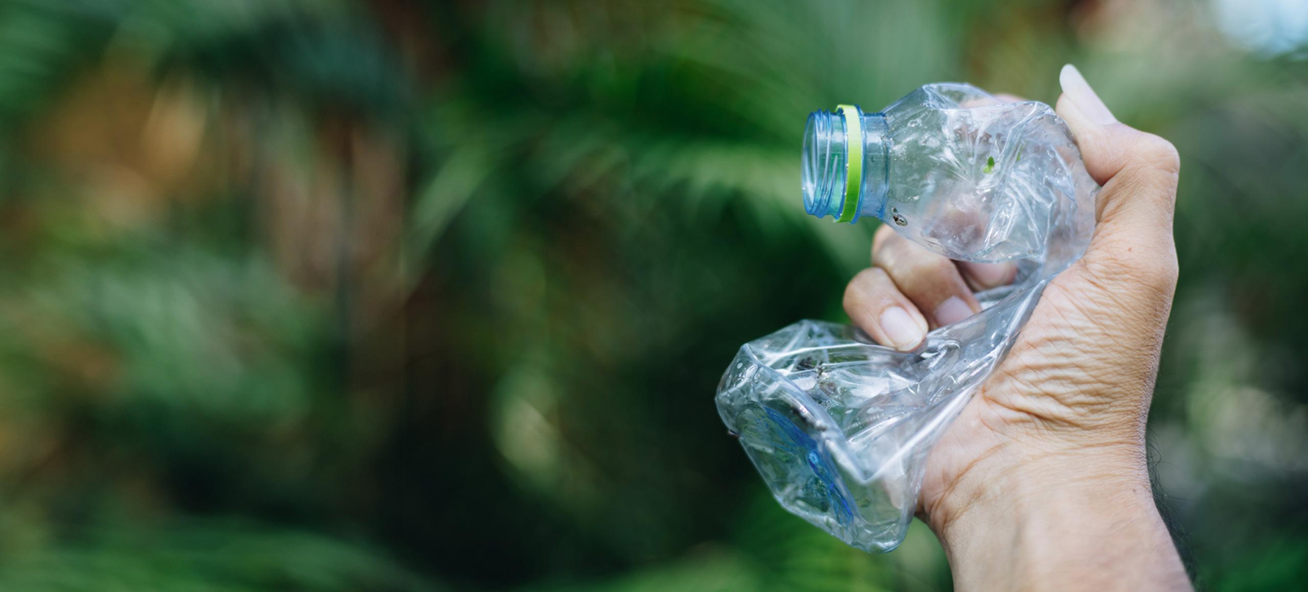 Plastic water bottle being crushed in somebody's hand
