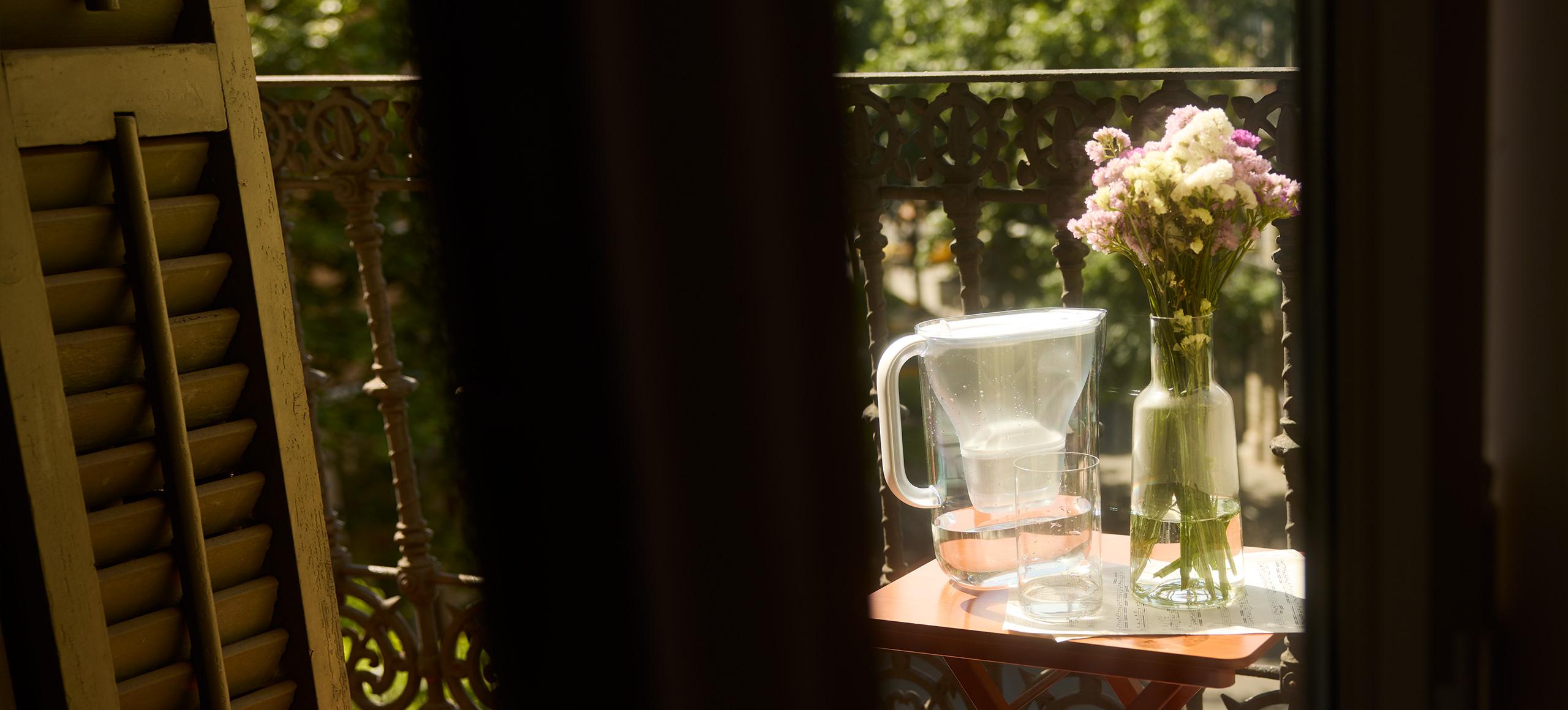 BRITA Jug on a table with some flowers on a balcony 